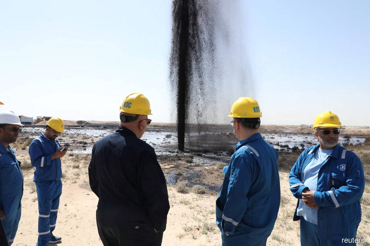 Workers from the Kuwait Oil Company meet at a site overlooking the site of oil spill in an unspecified location, western region of Kuwait on March 20, 2023. (Reuters pic)